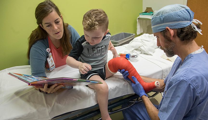 Child life helping child in cast