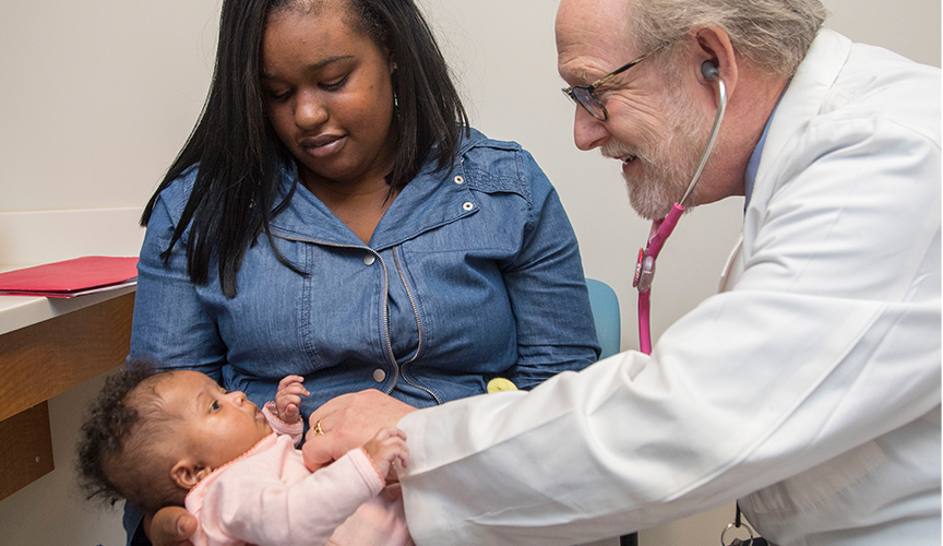 Dr. Towbin listens to a patient's heart in clinic.