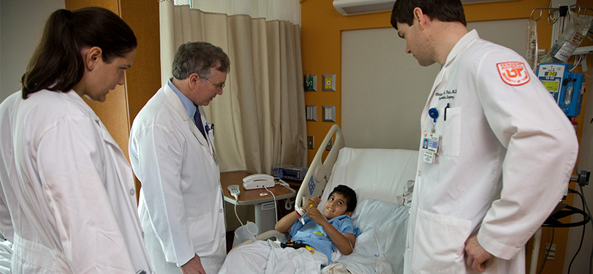 William Warner, MD seeing a pateint at Le Bonheur Chidlren's Hospital alongside two Orthopeadic Fellows.