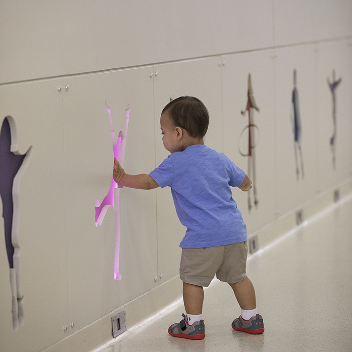 Little boy playing with wall lights